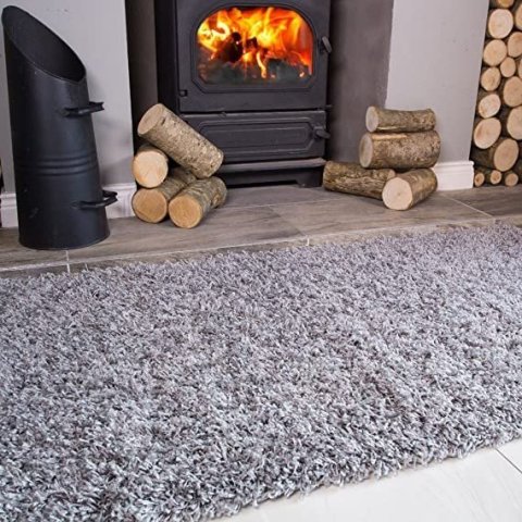 Grey shag rug laid in front of a lit wood-burning stove