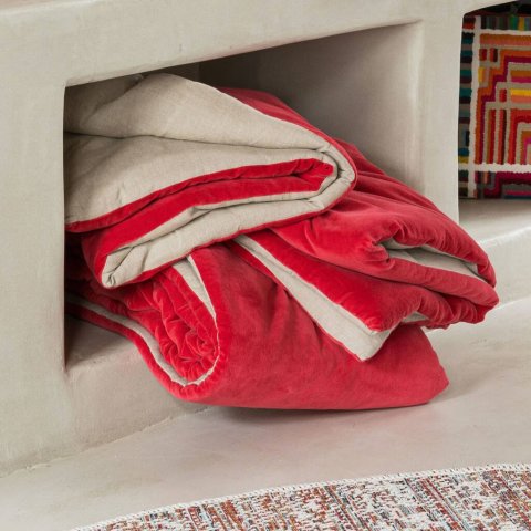 Folded red and cream throw blankets