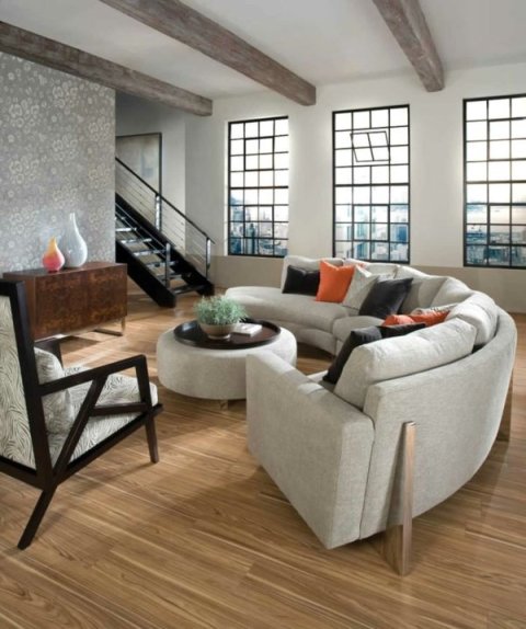Bright open-plan living room with a curved grey sectional sofa