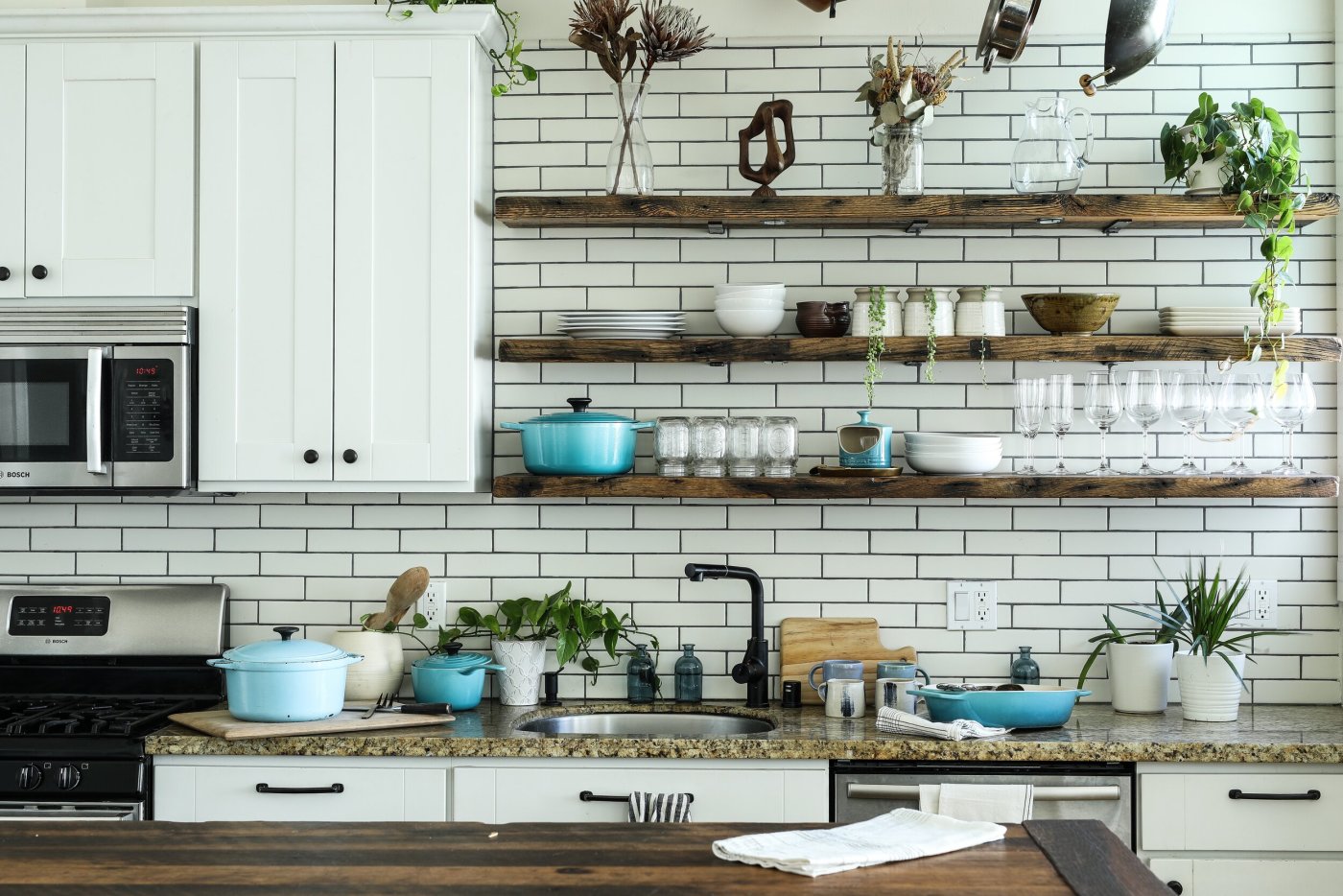 Bright open kitchen with potted plants and a dining nook