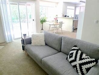 Bright decluttered living room opening onto the kitchen and garden